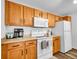 Practical kitchen with wooden cabinetry, white appliances, and ample counter space at 5765 N Genoa Way # 1-103, Aurora, CO 80019