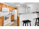 Functional kitchen with wood cabinets, modern appliances, and a breakfast bar at 5765 N Genoa Way # 1-103, Aurora, CO 80019