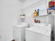Functional laundry room featuring a washer, dryer, and overhead shelving for storage solutions at 5765 N Genoa Way # 1-103, Aurora, CO 80019