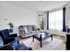 Stylish living room with hardwood floors, comfortable sofa, accent chairs, and views of outdoor greenery at 5765 N Genoa Way # 1-103, Aurora, CO 80019