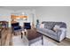 Open-concept living space with modern furniture, kitchen view, and hardwood floors at 5765 N Genoa Way # 1-103, Aurora, CO 80019