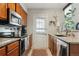 Functional kitchen featuring wood cabinets, stainless appliances, granite counters and backyard access at 8220 W 90Th Pl # 2003, Broomfield, CO 80021