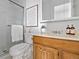 Bathroom with wooden vanity, framed mirror, adjacent to a shower with glass doors at 3981 S Boston St, Denver, CO 80237