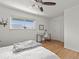 Bright bedroom featuring a bed, ceiling fan, wood floors, and a bright window with a view at 3981 S Boston St, Denver, CO 80237