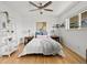 A bright bedroom features a bed, ceiling fan, hardwood floors, and built in ladder shelving at 3981 S Boston St, Denver, CO 80237