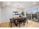 Dining room features wooden table with six chairs, modern lighting, and access to the outdoors at 3981 S Boston St, Denver, CO 80237