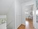 Bright hallway with a linen closet and wood floors leads to a bedroom with a desk and chair at 3981 S Boston St, Denver, CO 80237