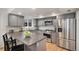 Updated kitchen with stainless steel appliances, gray cabinets, granite countertops and tile backsplash at 3981 S Boston St, Denver, CO 80237