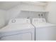 Bright laundry room featuring a white washer and dryer, and convenient shelving above for storage at 3981 S Boston St, Denver, CO 80237
