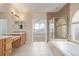Bathroom with double sinks, glass-enclosed shower, soaking tub and arched window view to bedroom at 1445 Colebrook Ct, Castle Rock, CO 80109