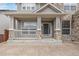 Charming front porch with stone accents, neutral colored siding, and a well-manicured lawn at 1445 Colebrook Ct, Castle Rock, CO 80109