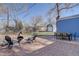 The backyard features a blue house, brick patio with furniture, and a shed at 4260 Newland St, Wheat Ridge, CO 80033