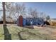 Backyard featuring a blue house, brick patio with a fire pit, and a grassy lawn at 4260 Newland St, Wheat Ridge, CO 80033
