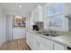 Bright kitchen featuring white cabinets, stainless sink, and adjacent laundry area for added convenience at 4260 Newland St, Wheat Ridge, CO 80033