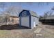 Blue shed with a white garage door and a single entry door in the backyard at 4260 Newland St, Wheat Ridge, CO 80033