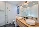 Beautiful bathroom featuring wood vanity with double sinks, glass enclosed shower, and modern fixtures at 3829 Osage St, Denver, CO 80211