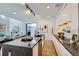 Open concept kitchen showcasing a large island, white cabinets, stainless steel appliances, and modern finishes at 3829 Osage St, Denver, CO 80211