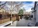 Back deck with chairs, table, and grill overlooking fenced yard and mature trees at 11335 Haswell Dr, Parker, CO 80134