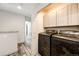 Upstairs laundry area with gray cabinets and modern machines at 11335 Haswell Dr, Parker, CO 80134