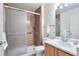A full bathroom with an updated vanity, sliding glass shower doors, and contemporary fixtures at 5872 W Asbury Pl, Lakewood, CO 80227