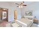 Cozy bedroom with a ceiling fan, soothing colors, and a glimpse into the bathroom at 5872 W Asbury Pl, Lakewood, CO 80227