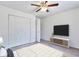 A clean bedroom offers a ceiling fan, spacious closet, and a sleek TV mounted on the wall at 5872 W Asbury Pl, Lakewood, CO 80227