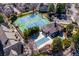 Aerial view of the community featuring an outdoor pool, tennis courts, and mature landscaping at 5872 W Asbury Pl, Lakewood, CO 80227