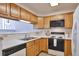 Bright kitchen with wooden cabinets, white countertops, and essential appliances at 5872 W Asbury Pl, Lakewood, CO 80227