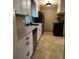 Galley kitchen features modern appliances, neutral countertop, tile backsplash and crisp white cabinetry at 1364 Iola St, Aurora, CO 80010