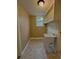A practical laundry room features a utility sink, shelving, and a window for natural light at 1364 Iola St, Aurora, CO 80010