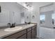 Dual sink bathroom with dark cabinets, modern fixtures, and neutral decor at 3318 N Haleyville Ct, Aurora, CO 80019
