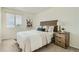 Bright bedroom features a woven headboard, bedside table, and a window offering natural light at 9544 Josephine St, Thornton, CO 80229
