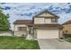 Charming tan two-story home with brick accents, well-manicured lawn, and an attached two-car garage at 9544 Josephine St, Thornton, CO 80229