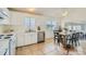 A well-lit kitchen featuring white cabinets, stainless steel appliances, tile floors, and a spacious dining area at 9544 Josephine St, Thornton, CO 80229