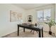 Bright office space featuring a dark desk, shelving with plants, and natural light from window at 9544 Josephine St, Thornton, CO 80229