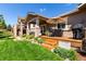 Beautiful backyard with lush green lawn, landscaped garden beds, and a cozy covered patio at 23644 E Phillips Pl, Aurora, CO 80016