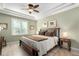 Comfortable bedroom featuring a trey ceiling, natural light, and wooden furnishings at 23644 E Phillips Pl, Aurora, CO 80016