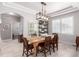 Bright dining room with a wooden table, six chairs, modern light fixture, and large window at 23644 E Phillips Pl, Aurora, CO 80016