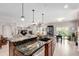 Spacious kitchen island featuring a sink, dishwasher, granite countertops, and pendant lighting at 23644 E Phillips Pl, Aurora, CO 80016