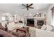 Inviting living room with a stone fireplace, ceiling fan, and arched entryway to other rooms at 23644 E Phillips Pl, Aurora, CO 80016