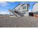 View of the home's exterior with a walkout deck and stairs, featuring a gravel ground cover at 1110 Black Saddle St, Elizabeth, CO 80107