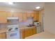 Bright kitchen featuring natural wood cabinets and white appliances at 2500 S York St # 213, Denver, CO 80210