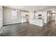 Open-concept kitchen with white cabinets, stainless steel appliances and wood flooring at 13497 Valentia St, Thornton, CO 80602