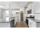 Open kitchen with island, stainless steel appliances and pantry access at 13497 Valentia St, Thornton, CO 80602