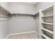 Empty walk-in closet featuring carpeted floors and open shelving at 13497 Valentia St, Thornton, CO 80602