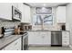 Close-up of a kitchen featuring stainless steel appliances, a modern sink, and white cabinets at 6240 W 24Th Ave, Edgewater, CO 80214