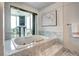 Luxurious bathroom featuring a deep soaking tub with jets and expansive windows with a view at 1900 E Girard Pl # 901, Englewood, CO 80113