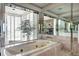 Luxurious bathroom with an elegant tub, marble tile, and a large window with shutter blinds at 1900 E Girard Pl # 901, Englewood, CO 80113