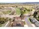 An aerial shot captures the house and neighborhood, revealing an open field and winding roads nearby at 2590 S Independence St, Lakewood, CO 80227