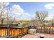 A backyard deck features wooden railings and a brick floor with views of trees in the distance at 2590 S Independence St, Lakewood, CO 80227